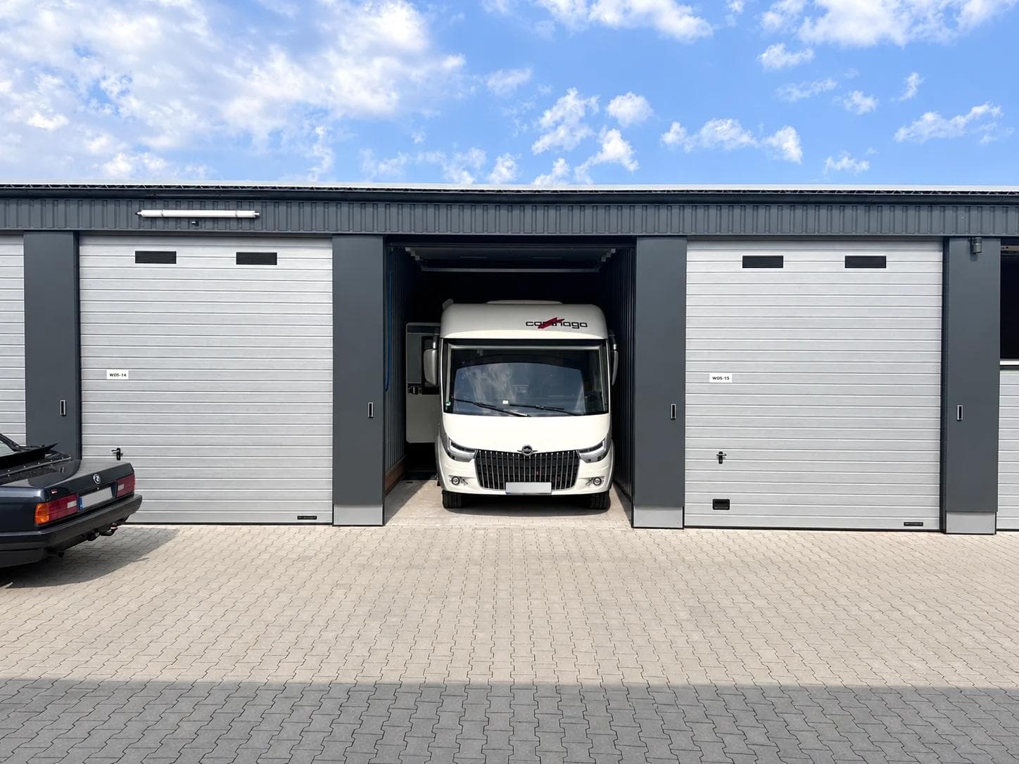 Wohnmobil vor einer geöffneten Garagenbox von Mega Mietpark zur Einlagerung über den Winter